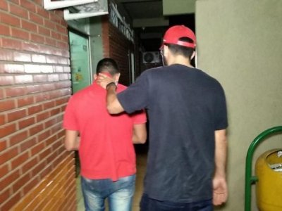 Suspeito, de camiseta vermelha,  levado para a delegacia (Foto: Adilson Domingos)