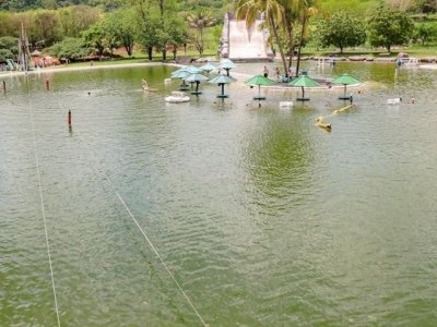 À esquerda da imagem, cabos que sustentam os banhistas que se lançam na tirolesa do lago