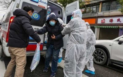 Mdicos ajudam paciente a sair de uma ambulncia em Euhan (Foto: Chinatopix via AP)