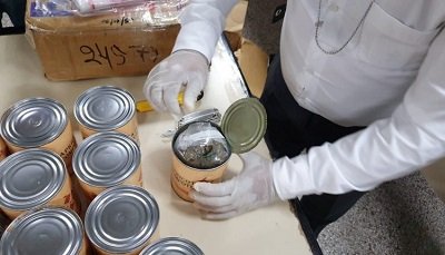 Latas de pssegos com maconha. (Foto: Senad)