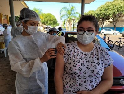 Profissional de saúde aplica vacina contra a covid em adolescente em Aquidauana