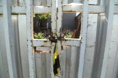 Fita zebrada encontrada no portão da vítima nesta manhã marcava o local da troca de tiros (Foto: Kísie Ainoã)