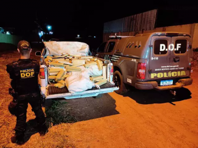 Policial ao lado da caminhonete abarrotada de maconha. (Foto: DOF)