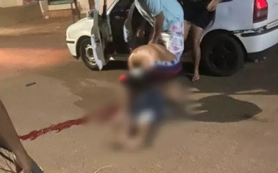 Jovem sendo socorrido por moradores do bairro. (Foto: Jornal Cenrio MS)