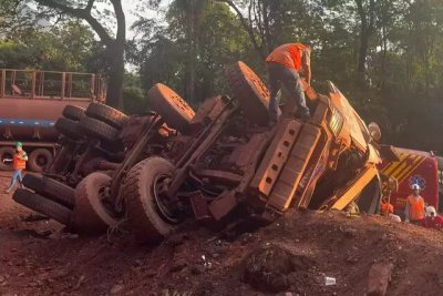 Caminhão tombado e bombeiros no local fazendo o trabalho de resgate. (Foto: Divulgação)