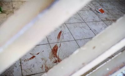 Manchas de sangue no cho do imvel onde rapaz foi baleado. (Foto: Henrique Kawaminami)