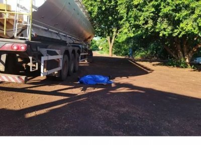 Corpo de motorista cado ao lado de caminho e coberto com pano. (Foto: Dourados News)