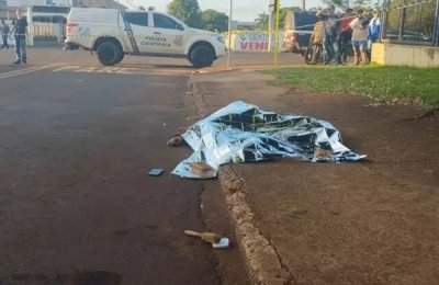 Moradores observam corpo cado na calada, na Rua Natal, regio leste de Dourados (Foto: Leandro Hosbach)