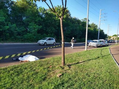 Corpo da vtima coberto por lenol em avenida. (Foto: Kamila Alcntara)