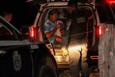 Suspeito sendo colocado em viatura da PM para ser levado a delegacia (Foto: Juliano Almeida)