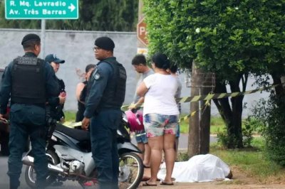 Corpo da vtima coberto com lenol branco e ao lado policiais militares e a famlia do homem (Foto: Henrique Kawaminami)