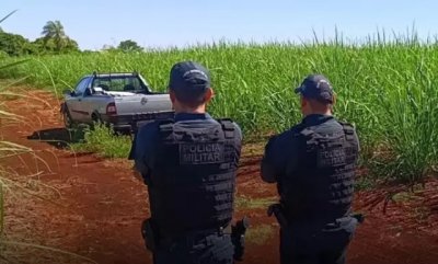 Policiais no local atrs de carro onde vtima foi encontrada morta. (Foto: Divulgao)
