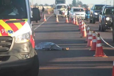 Corpo da vtima coberto por lenol na pista da BR-163 (Foto: Marcos Maluf)